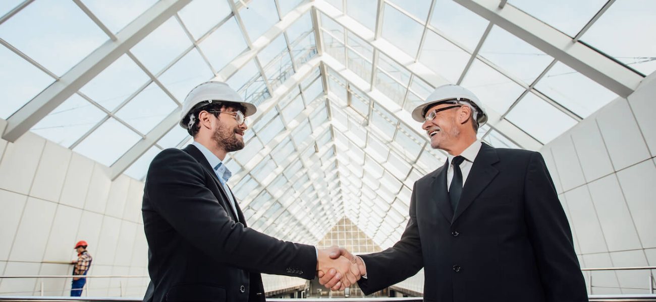 construction men in suits shaking hands